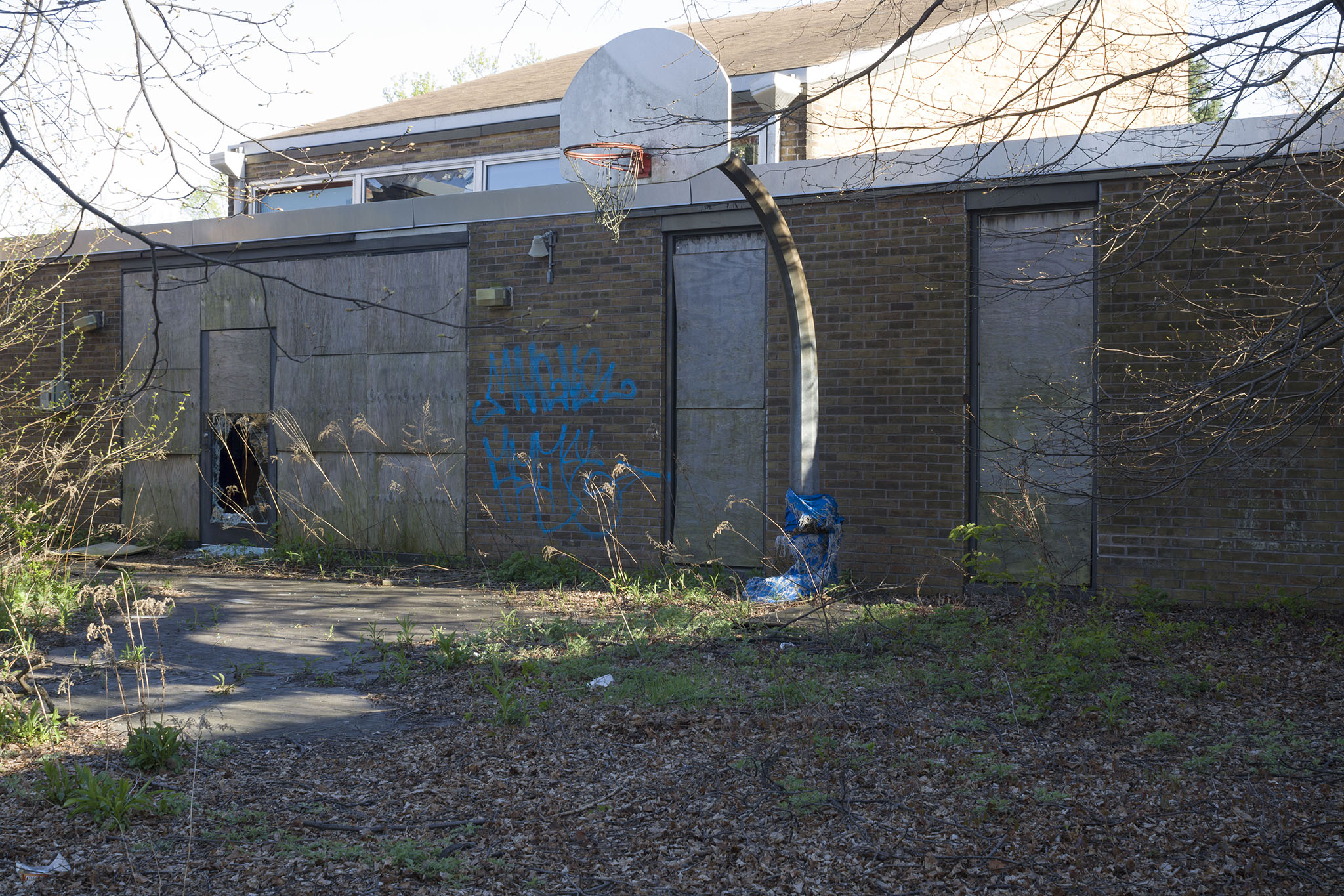A lone basketball hoop sits in the courtyard area.